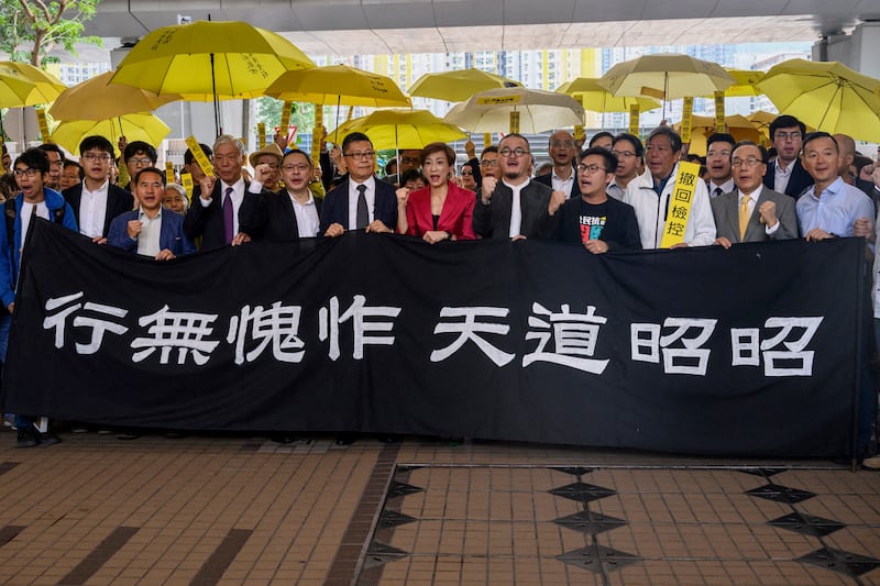 From left to right: pro-democracy activists Chung Yiu-wa, Cheung Say-yin, former Democratic Party lawmaker Lee Wing-tat, baptist minister Chu Yiu-ming, 74, law professor Benny Tai, 54, sociology professor Chan Kin-man, 59, lawmakers Tanya Chan and Shiu Ka-chun, and League of Social Democrats vice-chairman Raphael Wong, chant before entering the West Kowloon Magistrates Court in Hong Kong on Nov. 19, 2018.