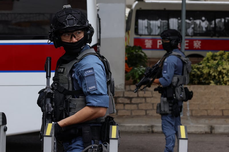 Members of the Police Counter Terrorism Response Unit stand guard as they escort a prison van believed to be carrying Jimmy Lai to the West Kowloon Magistrates’ Courts building in Hong Kong, Aug. 18, 2025.