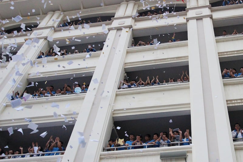 Students throw out used exam papers and other study materials at a pressure release activity before the upcoming China's college entrance exam at a high school in Fujian province, May 20, 2016.