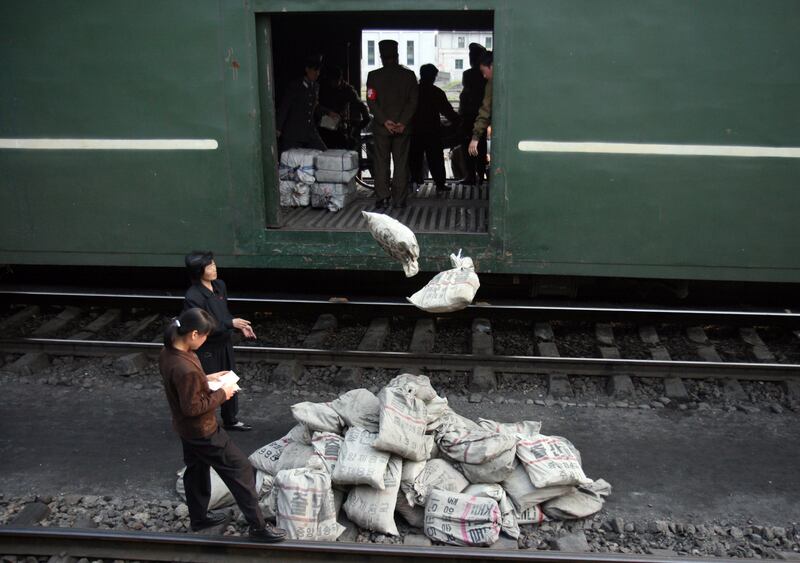 북한 병사들이 평양 외곽에서 쌀 포대를 열차에서 내리고 있다.