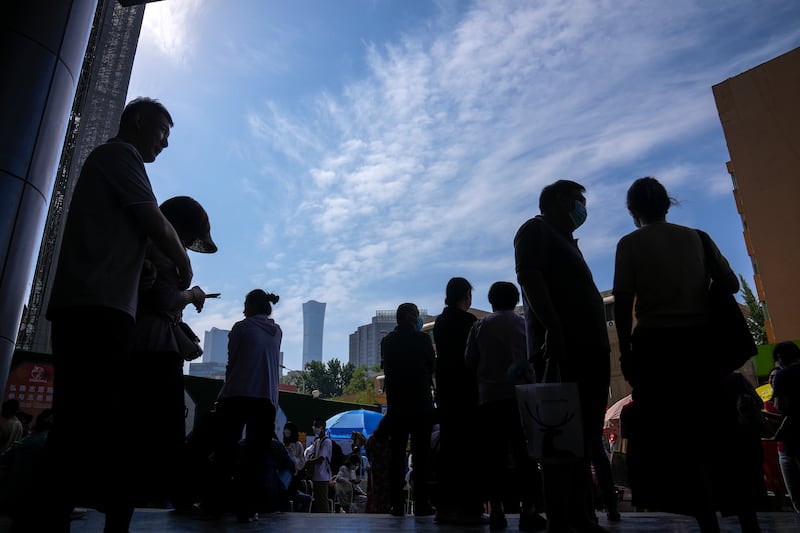 Parents wait near a school during the first day of China's national college entrance examinations in Beijing, June 7, 2023.