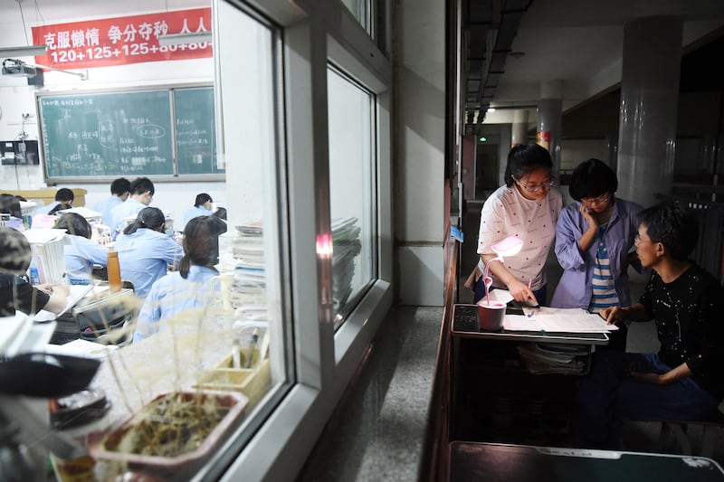 This May 23, 2018, photo shows a high school teacher answering questions ahead of the college entrance examinations in China's northern Hebei province.